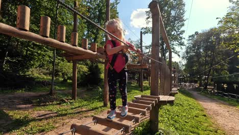 Glückliches-Kleines-Mädchen,-Das-In-Der-Tarzan-Attraktion-Auf-Dem-Spielplatz-Im-Vergnügungspark-Spielt