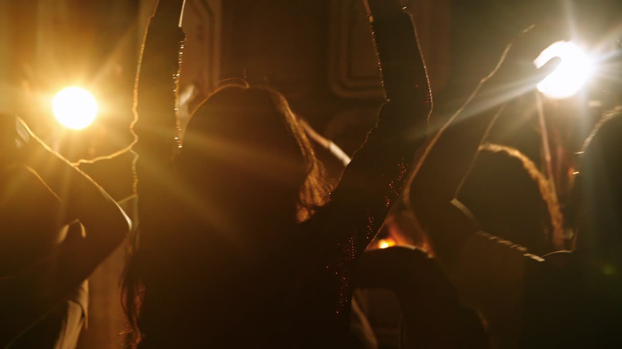 siluetas de personas bailando con las manos en el aire