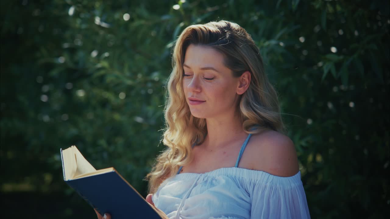 Giovane donna che legge un libro all'aperto in un parco