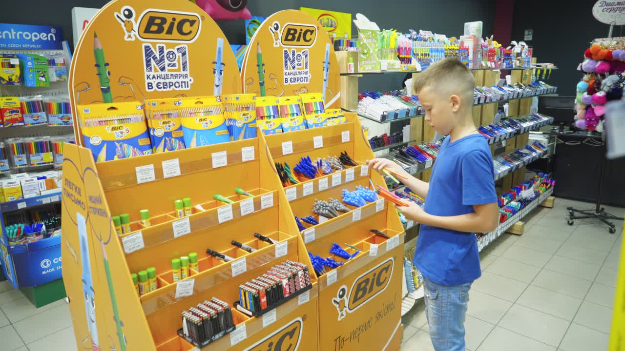 VINNITSA, UKRAINE - AUGUST 20, 2018: Boy in the stationery store choose goods for school and office. Back to school
