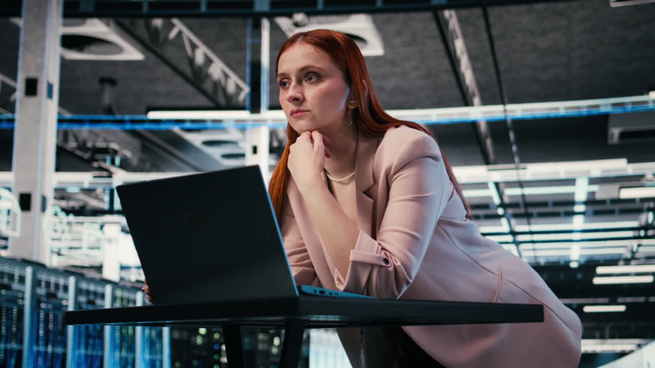 Professionista IT donna concentrata sul portatile in un data center