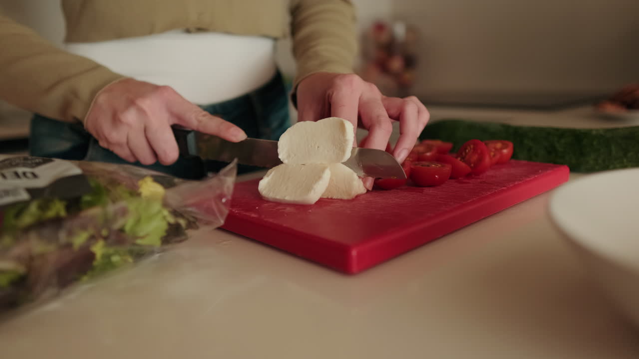Woman Slicing Mozzarella for Fresh Salad. Healthy food close up