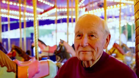 elderly man enjoying a carousel ride