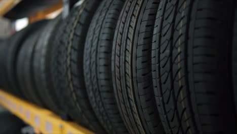 car tires on rack in auto store, close up of car wheels at the auto repair shop.