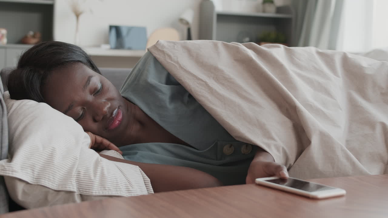 African Woman Waking Up because of Phone Call