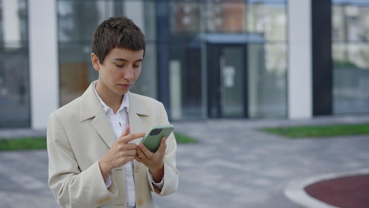 Woman using smartphone outside modern building