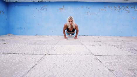 Una-Mujer-Joven-Haciendo-Flexiones-En-Un-Piso-De-Concreto-Al-Aire-Libre