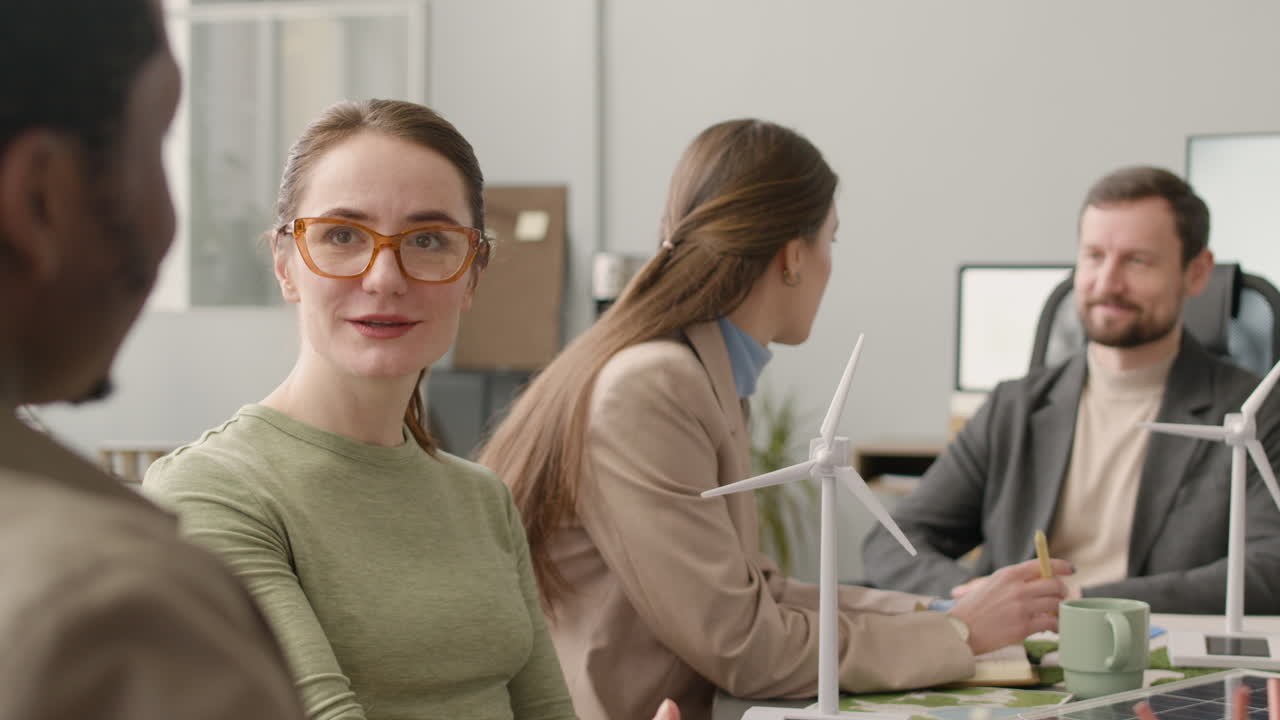 многонациональная бизнес-команда обсуждает проект по возобновляемой энергии в офисе 9
