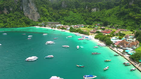 boats docked near tropical island of phi phi, aerial drone view