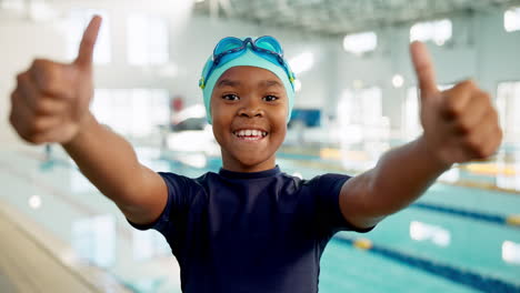child swimmer giving thumbs up in swimming pool