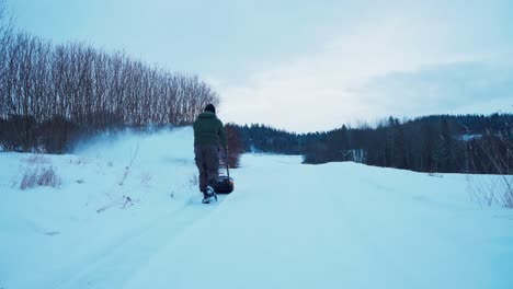 la parte trasera de un hombre con un camino de limpieza de soplador de nieve cubierto de nieve