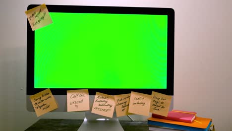 persona añadiendo notas pegajosas a un monitor de computadora