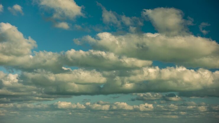 Layers and layers of white clouds moving across the frame in a blue sky
