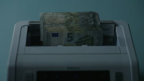 euro banknotes being counted by a machine