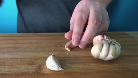 Frischen-Knoblauch-Auf-Einem-Holzschneidebrett-In-Der-Küche-Schälen-Und-In-Scheiben-Schneiden