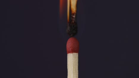 mano encendiendo un fósforo contra el otro súper primer plano macro tiro capturado en fondo negro en cámara lenta a 60 fps.