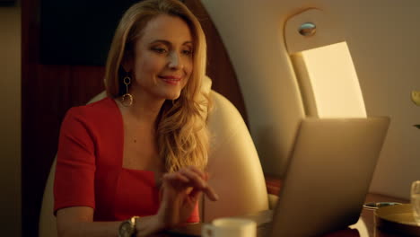 empresario feliz navegando por internet en un avión privado. elegante dama de descanso