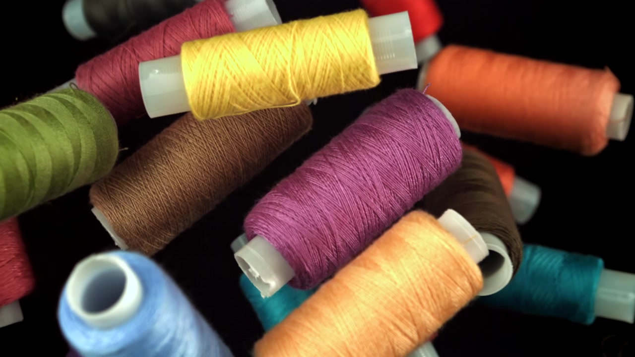 Colorful Spools of Thread Falling in Slow Motion