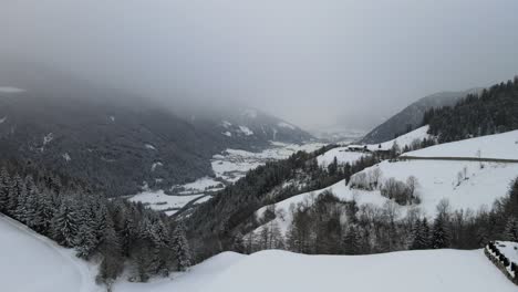 Tormenta-De-Nieve-De-Mal-Humor-Oscuro-En-Los-Alpes-Italianos,-Puedes-Ver-Un-Valle-Frío-Y-Un-Pueblo