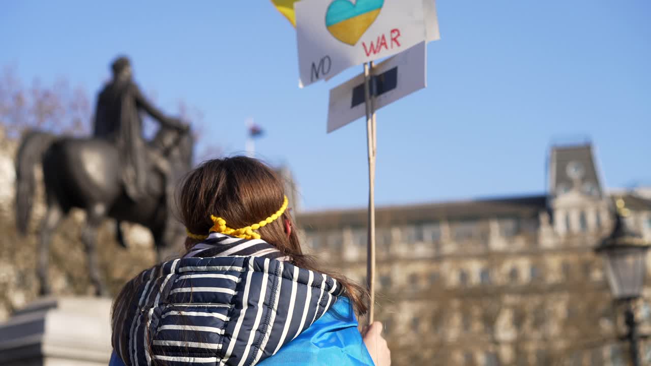 londres está del lado de ucrania, un niño protesta agitando un signo de paz, un manifestante en la plaza de trafalgar en londres durante una protesta contra la guerra con rusia