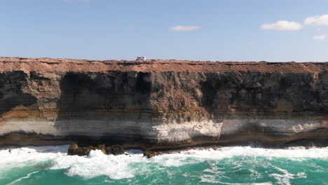 campervan parked on top of steep cliffs over disturbed waters