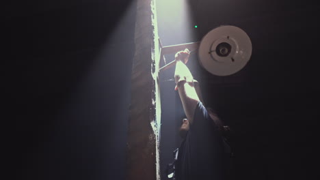 man lifting lamp on wooden beam