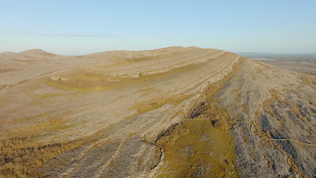 las líneas estratigráficas se extienden a lo largo de las colinas de piedra caliza en un día soleado con paredes de roca en la irlanda de burren.