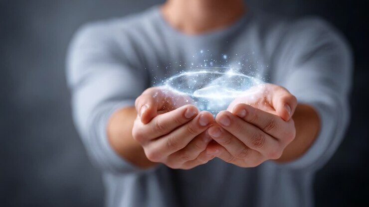 Osoba jemně drží zářící sféru energie ve svých rukou, což ukazuje krásu a sílu kreativity a představivosti v mystickém světle