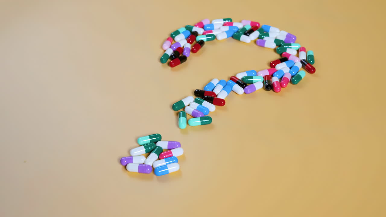 Pílulas, comprimidos e cápsulas em formato de símbolo de ponto de interrogação, simbolizando escolhas na área da saúde, dúvidas sobre medicamentos e incertezas de tratamento. Ideal para projetos médicos e relacionados à saúde.
