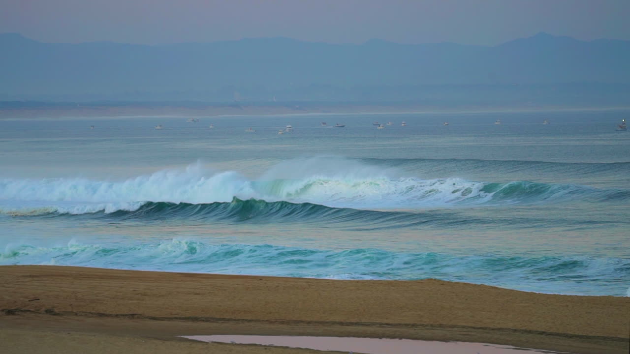 영화적 인 놀라운 이른 아침 거대한 물결이 부풀어 오르며 세일보트와 가까운 모양으로 호세고르 세이그노스 프랑스 분홍색 보라색 어두운 해가 해변에서 해가 뜨는 산 해안 풍경 비아리츠 바스크 국가 여전히