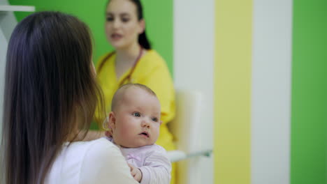 mother holding baby in her hands. mother with baby during medical appointment in clinic