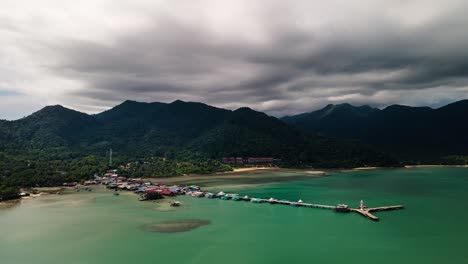 Imágenes-De-Drones-De-Lapso-De-Tiempo-De-4k-Que-Se-Ciernen-Sobre-El-Muelle-Y-El-Faro-En-La-Isla-De-Koh-Chang-Con-Cúmulos-De-Bajo-Nivel-Que-Se-Mueven-Sobre-Las-Selvas-Montañosas-En-Tailandia