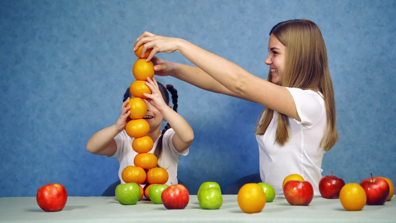 Child girl with fruits. Little cute child girl funny play construct with organic fruits