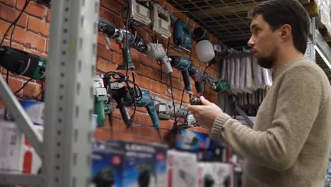 hombre mirando herramientas eléctricas en una ferretería