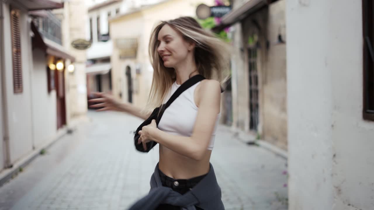 mujer rubia bailando al aire libre, girando alrededor, emocional