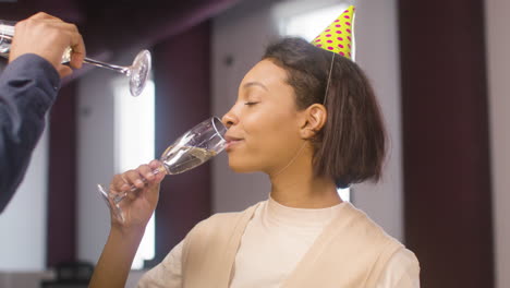 cerca de una mujer americana y un hombre sosteniendo un vaso de chamapgen y hablando juntos en la fiesta de la oficina