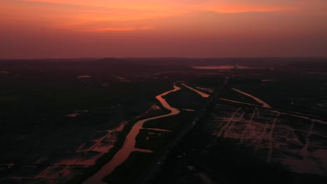 cielo rojo al anochecer sobre el arroyo en vasai, mumbai, india