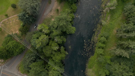 top down shot of a bridge in west lynn oregon and following the tualatin river flow into the willamette on a partly cloudy day.