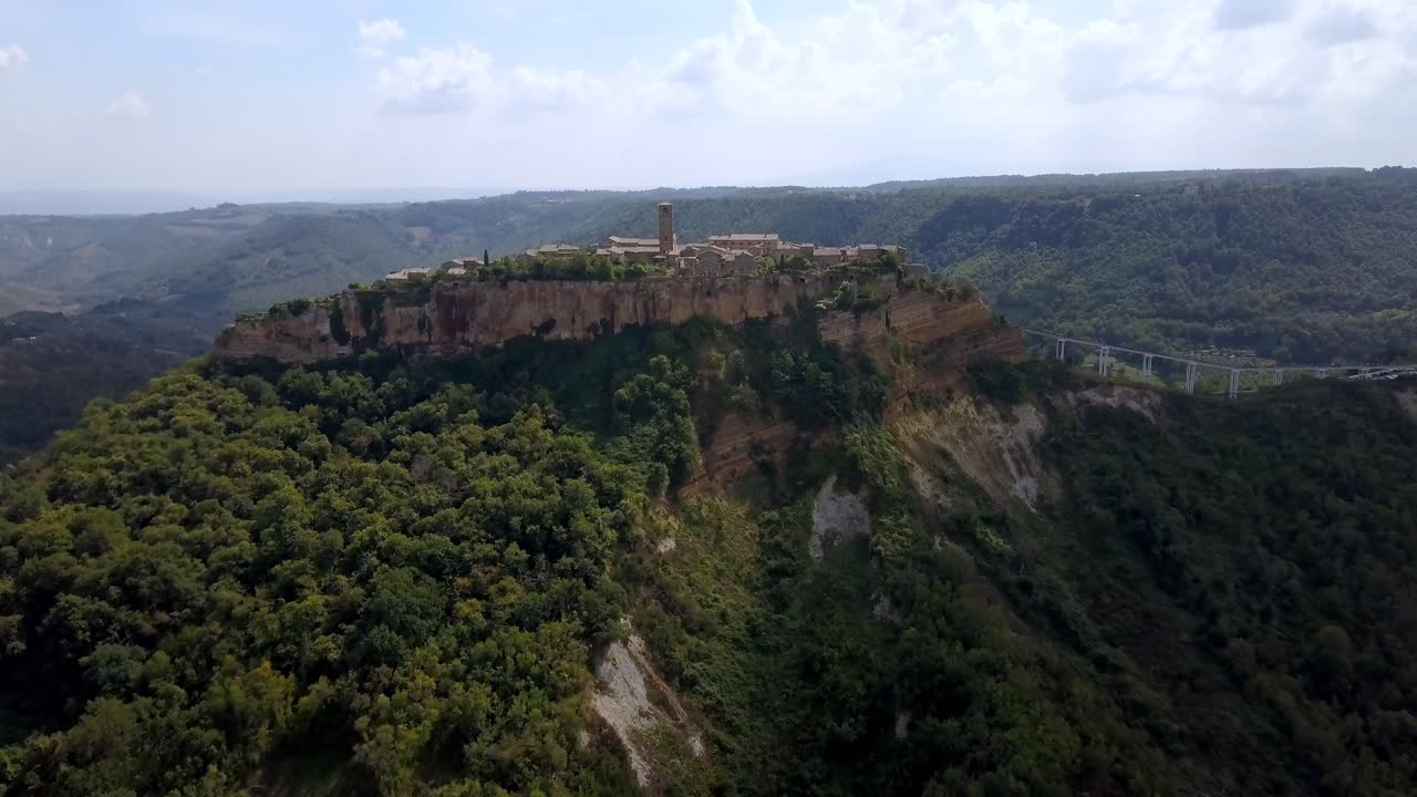 pueblo de civita di bagnoregio en toscana italia con acantilados erosionados y puente, toma aérea de aproximación
