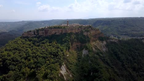Village-of-Civita-di-Bagnoregio-in-Tuscany-Italy-with-eroding-cliffs-and-bridge,-Aerial-approach-shot