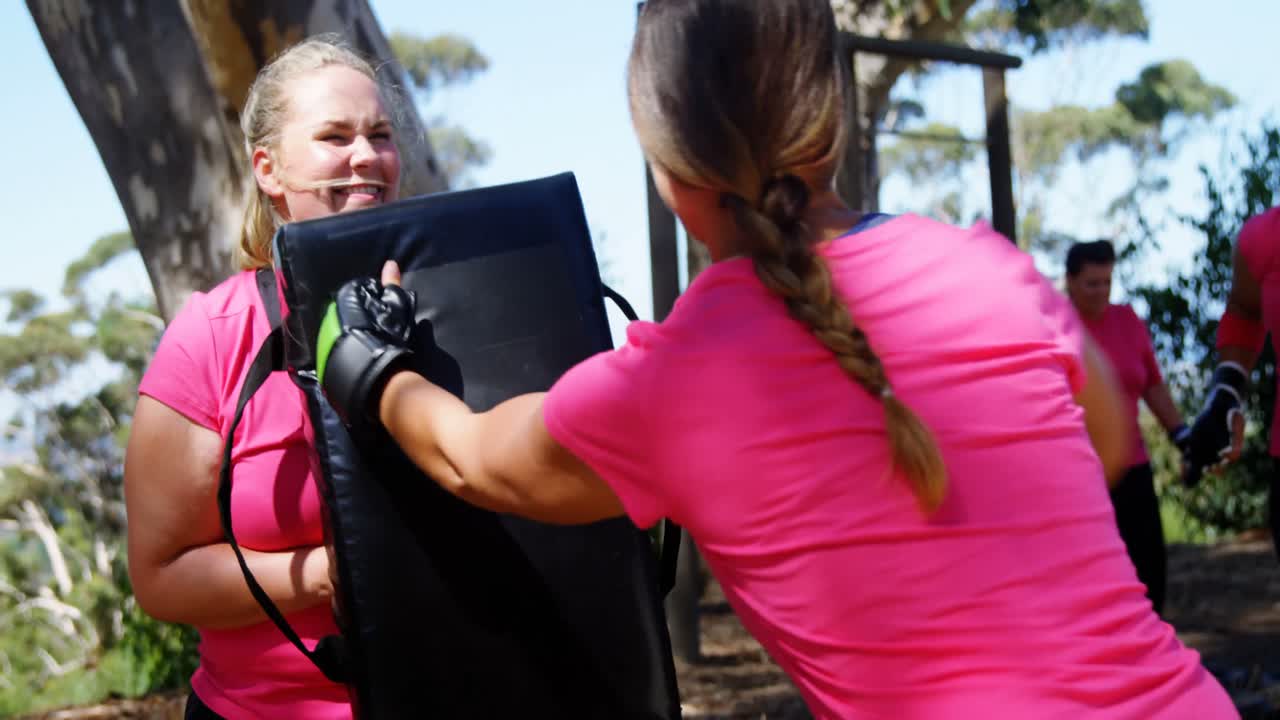 mujer practicando boxeo en el campamento de entrenamiento