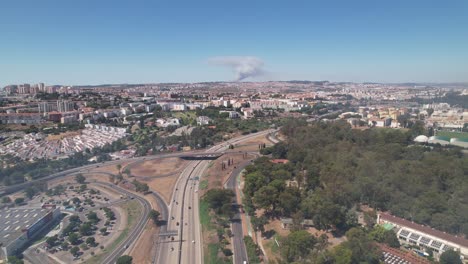 drone pan shot of the lisbon city fire event from a distance. highway traffic in portugal