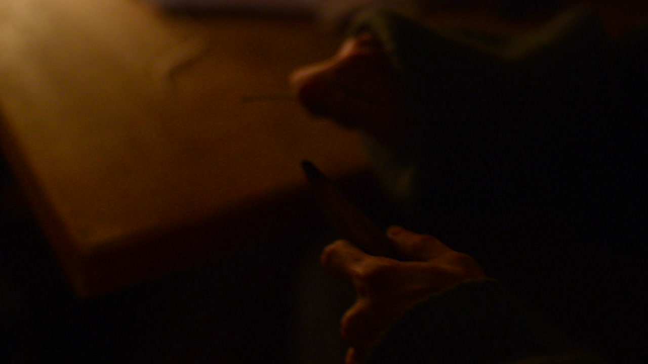 hombre afilando un trozo de madera y colocándolo en el fuego