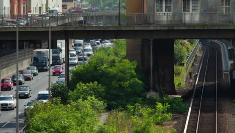 city street with traffic, train tracks, and overpass