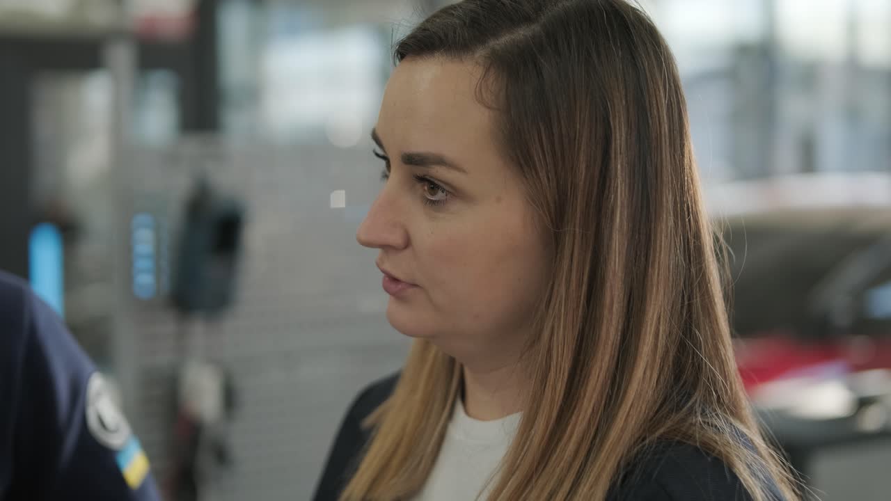 Responsabile donna che discute di riparazione veicoli con un meccanico in un'autofficina.