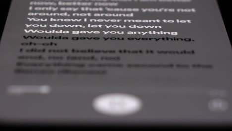 highlighted lyrics from song scrolling on mobile phone, close up macro shot