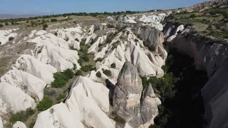 drone circles a rock formation, a troglodyte dwelling in red rose valley, cappadocia, turkey