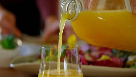 close-up of juice being poured into glass at home 4k