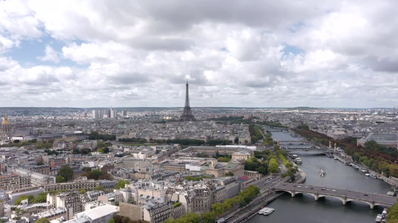 A breathtaking aerial drone shot captures the Eiffel Tower rising above Paris with the Seine River winding through the city’s historic skyline