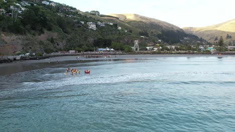 Descenso-Aéreo-Hacia-Los-Competidores-De-Inicio-De-Natación-De-Triatlón-Mientras-Se-Preparan-Los-Salvavidas-De-Surf---Bahía-De-Scarborough,-Sumner